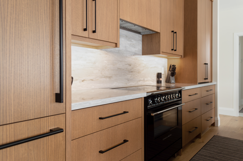 Rift-Cut White Oak cabinets, Under cabinet LED lighting, and beautiful Hanstone quartz countertops and full height backsplash. - Burlington, Ontario Designed by: EKR Designs